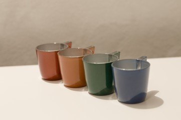 Four colored coffee cups on a white table (Pesaro, Italy, Europe)