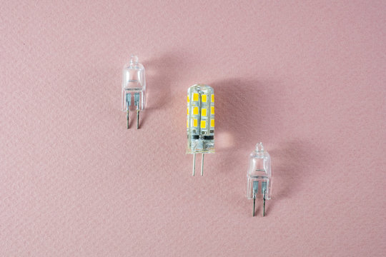 Two halogen and one modern eco LED type arranged diagonally on a pink background- technology shift