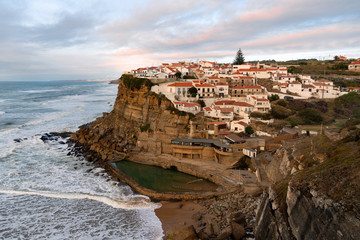 Fototapeta na wymiar View of the Picturesque village Azenhas do Mar, on the edge of a cliff with a beach below. Landmark near Sintra, Lisbon, Portugal, Europe. landscape at sunset.