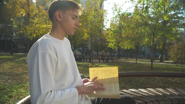 Young man is reading book it the park