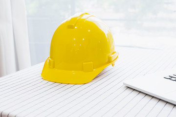 Helmet placed on a yellow desk and close to the laptop.