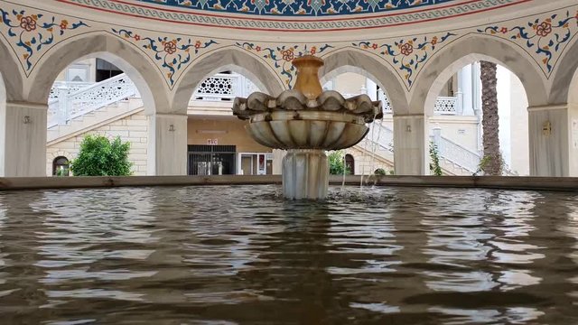Fountain for ablution in the mosque. Water flows from the fountain to the water surface of the pool.  Turkey. Manavgat