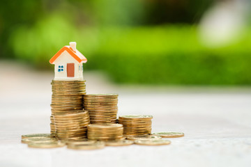 House model on top of stack of money coins. Business and finance, Property investment and asset management, Loan, Mortgage, Inflation, Sale and tax rise and Saving money for buy or rent home concept.