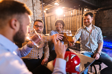 Men making a toast while their friend drinking water.