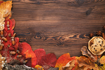 autumn leaves, cookies and cinnamon on wooden background