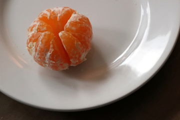 Peeled mandarin on plate
