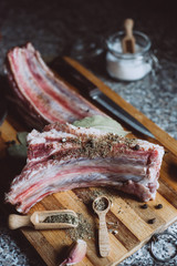  raw meat on wooden cutting board on dark background