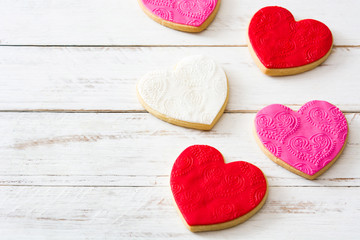 Fototapeta na wymiar Heart-shaped cookies for Valentine's Day on white wooden table. Copyspace