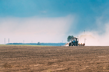 Fototapeta premium Tractor Plowing Field In Spring Season. Beginning Of Agricultura