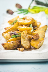 Roasted garlic herbs potato wedges. Selective focus, space for text.