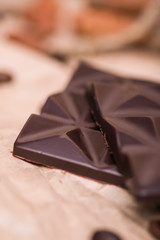 Black chocolate close-up on a light background. Coffee, chocolate on paper.