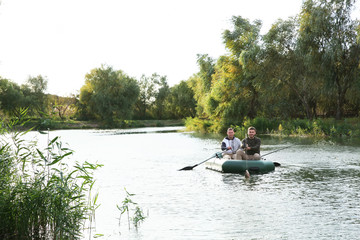 Fototapeta na wymiar Friends fishing from boat on river. Recreational activity