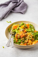 Warm quinoa and pumpkin salad in a white plate.