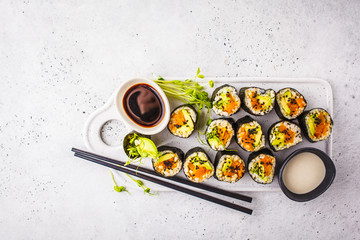 Vegan sushi rolls with pumpkin, brown rice and avocado, top view.