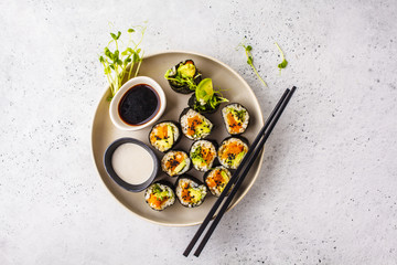 Vegan sushi rolls with pumpkin, brown rice and avocado, top view.