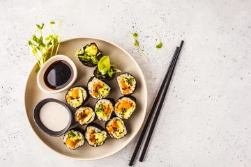 Foto auf Acrylglas Vegan sushi rolls with pumpkin, brown rice and avocado, top view. © vaaseenaa