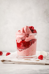 Vegan breakfast raspberry smoothie (ice cream) with berry jam in a jar.