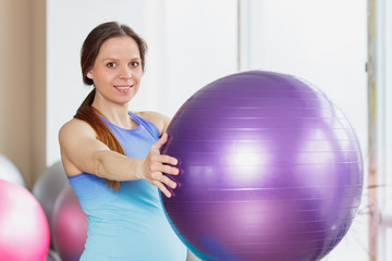 Fototapeta premium Pregnant sporty woman with an exercise ball in the hands
