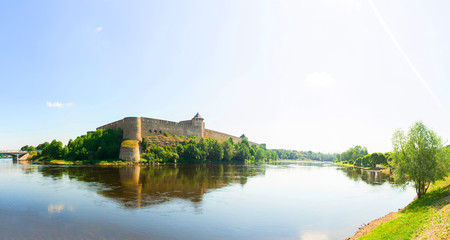 Fototapeta na wymiar Beautiful city landscape. Medieaval aged castle and river. Blue sky with clouds