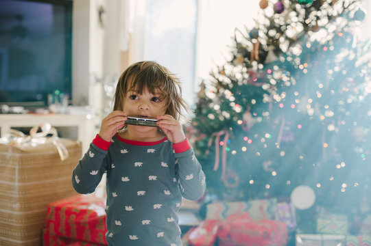 Boy playing with new harmonica on Christmas morning.
