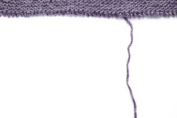 Unravelling knitted fabric on white background
