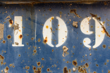 number hundred nine painted on rusty blue metal, number 109