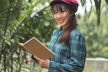 beautiful young Asia woman with reading book at outdoor garden.