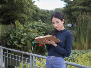 beautiful young Asia woman with reading book at outdoor garden.