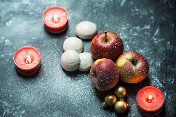 winter red apple and candles in a snow