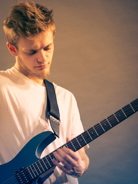 Young man playing electric guitar