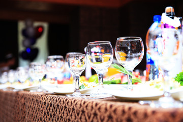 cheerful wedding celebration with a beautiful festive table, treats, champagne glasses, candles, flowers in the restaurant with a magnificent decor