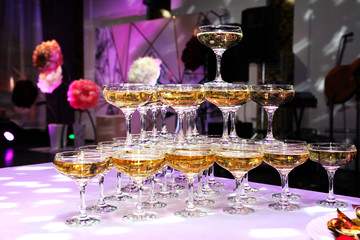 cheerful wedding celebration with a beautiful festive table, treats, champagne glasses, candles, flowers in the restaurant with a magnificent decor