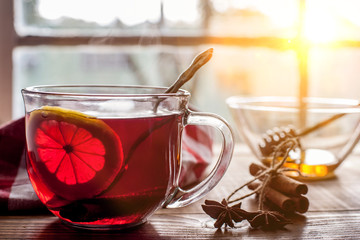Tea with lemon on table with sunny windows in back