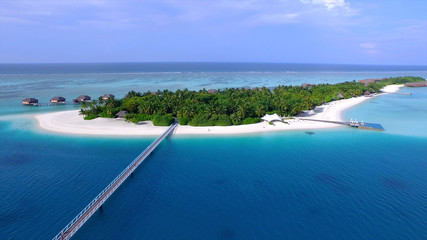 AERIAL: Wooden pedestrian bridge leading towards the beautiful exotic island.