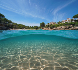 Mediterranean cove with houses and sand underwater sea, split view half above and below water surface, Costa Dorada, Spain, Cala Estany Tort, Catalonia, L'Ametlla de Mar, Tarragona