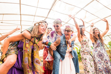 Fototapeta na wymiar Group of crazy happy females with different ages having fun together in friendship forever. Hippy colored trendy clothes for beautiful ladies in outdoor celebration. A lot of laugh and smile concept