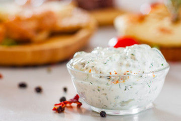 Greek Tzatziki sauce in a sauce-boat on table