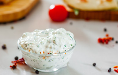 Greek Tzatziki sauce in a sauce-boat on table