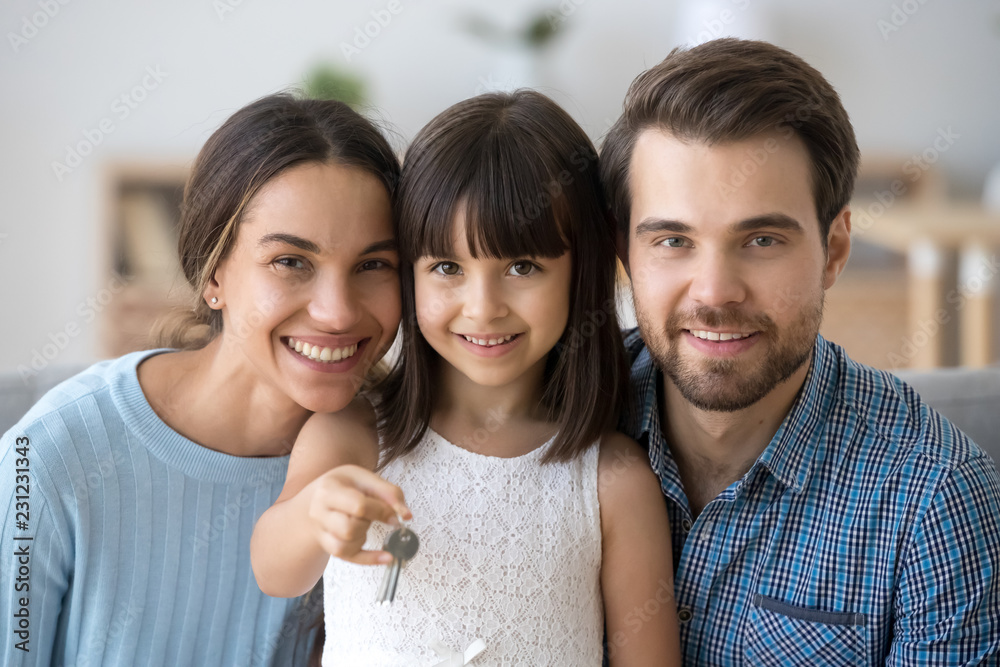 Wall mural head shot happy diverse family sitting on couch at new home. young married couple wife and husband t