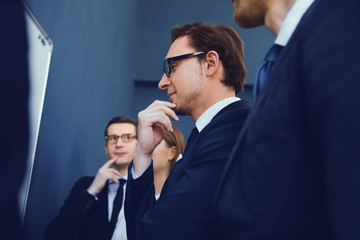 Business people having on presentation at office. Looking at data in pie chart on whiteboard.