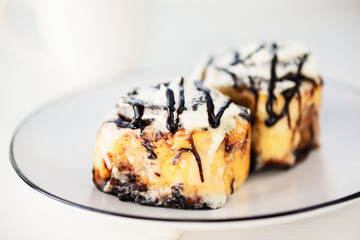 Cinnamon rolls with glaze on a plate. Fresh homemade cinnamon buns.