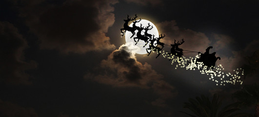 Santa flying over full moon