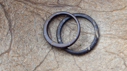 His and Hers handmade coconut rings with coconut interior background. Artisan wedding ring bands....
