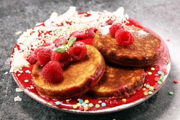 Pancakes with berries and maple syrup on rustic table
