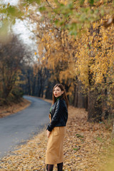 cozy stylish young girl walk at autumn park