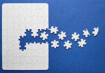 On a blue background, white puzzles and the missing piece