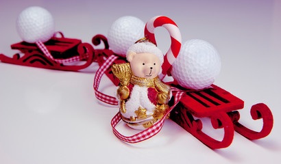 Funny polar bear wearing as Santa Claus and white golf balls on the red sleds. Christmas and New Year holiday background concept. Copy space for text.