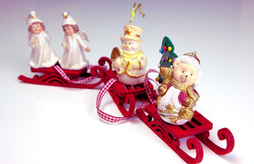 Cute snowman, two white angels, funny polar bear wearing as Santa Claus and Christmas tree are on the red sleds. Christmas and New Year holiday background concept. Copy space for text.