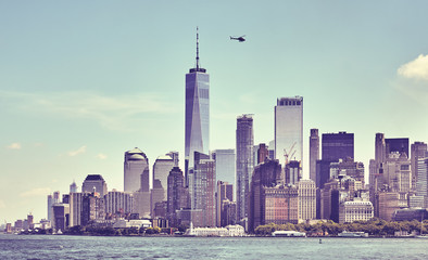 Obraz premium Retro toned picture of downtown New York skyline with hovering helicopter, USA.
