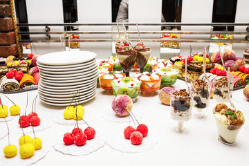Modern desserts, cupcakes, sweets with fruits. Delicious candy bar. Catering Concept.
